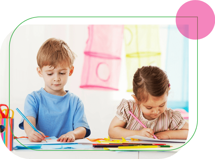 Two children are sitting at a table and writing.